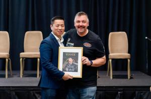 Tim McNeely accepts the 2025 Favorite Financial Services Award from Dr. Glenn Vo at Dental Podfest in Orlando.