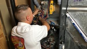 An Any Hour technician repairing a furnace.