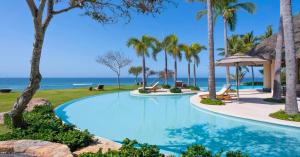 The pool surrounded with palm trees facing the pacific ocean at Casa Tres Solas in Mexico