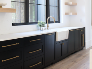 Modern black matte shaker kitchen cabinets with gold handles and a white farmhouse sink, provided by the best wholesale kitchen cabinet showroom in Las Vegas, Summerlin, and Henderson.