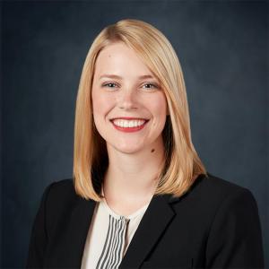 Professional headshot of Nichole Keddington, a Veterans Disability Attorney at Berry Law, smiling in business attire against a navy blue background.