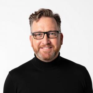 Headshot of Jason M. Riggs, technology executive and author.