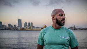 Most companies expanding into Spanish-speaking markets hire agencies, translators, and regional marketing teams Uncle Lou, bilingual media and outreach specialist for The Palyan Family AI System, standing by the waterfront in a teal shirt