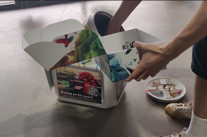 Person dropping used alkaline batteries into a free ResQ Batteries recycling bin at a Phoenix retail store
