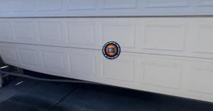 The Garage Door Repair Long Beach by On The Spot team holding the 