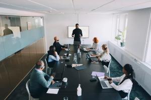Executive team in a boardroom reviewing 2026 cyber risk reality check on fraud versus ransomware to align CEO and CISO priorities.