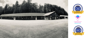 A black-and-white panoramic view of a long building surrounded by trees, featuring logos for certified autism and Down syndrome services.