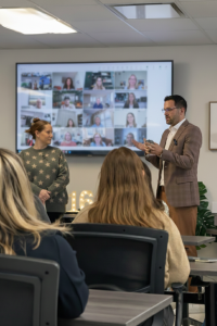 As small and mid-sized employers navigate increasing payroll complexity, evolving labor regulations, and heightened compliance scrutiny, consistency and clarity matter more than ever Kevin Welch speaking to Journey Payroll & HR team members during a company meeting with remote participants on screen.