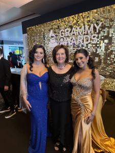 Farrah Mechael, family member, and Tamara Mechael posing together at the Grammy Awards Premiere Ceremony in front of the official Grammy Awards backdrop.