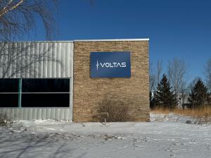 Picture of blue VOLTAS sign on brick exterior of building
