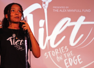 Actress Wynter Perrineau is telling an emotional, lively story on stage in front of a TILT backdrop.