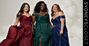 Three plus size models wearing off the shoulder satin prom dresses in burgundy, emerald green, and navy blue with draped bodices and flowing skirts for 2026 prom.