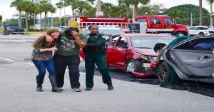 Student actors portraying injured teens during a staged car crash reenactment focused on teen driving safety education.