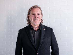 Jerry Hendriks, Broker of Record at REMAX Hendriks Team Realty, smiling in professional attire.