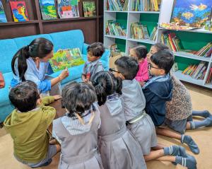 Photo of a Bookwallah volunteer surrounded by children during a story session