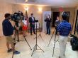 Hadi Suheil filming media coverage of a press conference during the COVID-19 pandemic