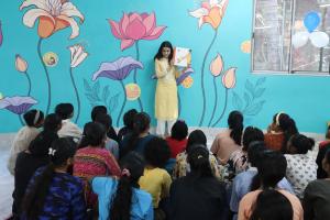Volunteer leads a story session in one of Bookwallah's Imagination Haven libraries, surrounded by a group of children