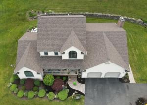 Aerial view of a completed roof replacement on a residential home near Gibsonia, PA with landscaping and driveway