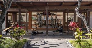 Open-air gym at Four Seasons Resort Hualalai, Hawaii, featuring strength and conditioning equipment with tropical garden surrounds, designed by Harley Pasternak of Gym by Harley