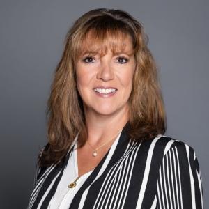 Professional headshot of Michele Vernola................. in a black and white striped blazer