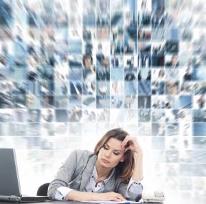 photo of woman sitting at a desk, with background of multiple images above her signify many many thoughts