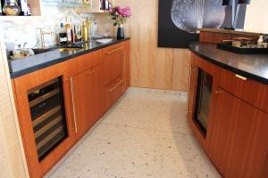 bar in residence with terrazzo floor and wood cabinets. 
