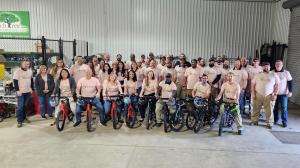 Peachtree Pest Control is proud to announce its 50th anniversary this year, marking five decades of service to the community Peachtree leaders stand together, wearing their volunteer shirts while posing with newly assembled bicycles lined up in front of them.