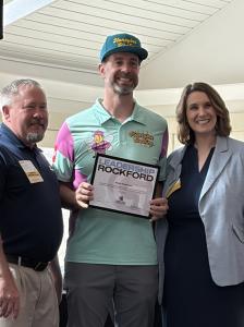 Adam Rossman President of Honeybee Roofing Presented With Leadership Rockford Graduation Certificate On Stage