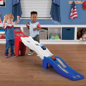 Simplay3 Celebrates American Manufacturing with Limited Edition Series 14 Two boys playing with a red, white, and blue racetrack. Two cars are sliding down.