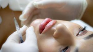Close-up of a young woman’s face highlighting smooth skin and youthful contours, representing aesthetic enhancement with Botox and dermal fillers.