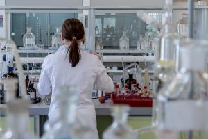 Female doctor in a laboratory setting reviewing data, representing evidence-based, science-driven telehealth care.