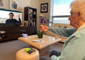 A senior connects with a telehealth provider through the television.