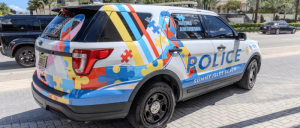 Police SUV in Sunny Isles Beach with colorful autism awareness puzzle piece graphics on the sides and rear.