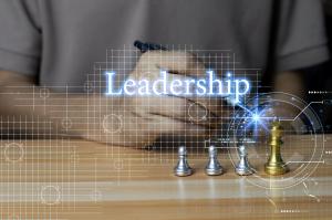 photo of a man at a chess board moving a piece with the word leadership in large letters
