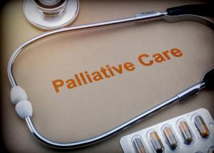 photo background of table stethscope on table picture of pills and large letters read Palliative Care