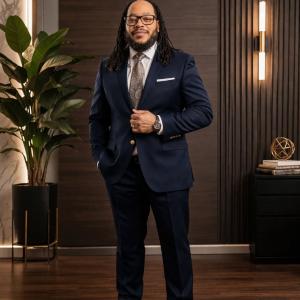 Photo of  Maurice W. Evans standing in a suit inside an office