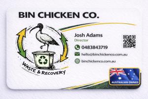 Business card for Bin Chicken Co. Waste & Recovery. Features the company logo — a hand-drawn white ibis standing on a wheeled recycling bin, surrounded by a circular arrow motif in yellow and green. Contact details: Josh Adams, Director. Phone: 0483843719