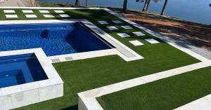 SuperSoft Deluxe artificial turf by Global Syn-Turf installed around pool and patio area with clean edges and natural green appearance