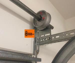 Technician replacing a broken high-cycle torsion spring on a residential garage door in Valencia, California