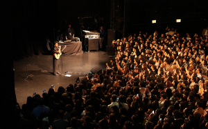 Anuv Jain performing on stage with a guitar in front of a large sold-out crowd during a US stop on the Dastakhat World Tour 2026, fans recording on phones (Photo by Faaiz Ghouri)