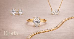 Moissanite fine jewelry set by Dloria Fine Jewelry featuring oval engagement ring, stud earrings, pendant necklace and tennis bracelet in gold vermeil on neutral background, showcasing modern luxury, high clarity stones, and timeless elegant design