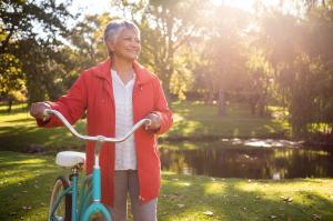 Photo of mature woman on bike looking hopefully ahead to future