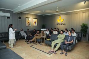 A group therapy session at Lifeline Rehab Center, with patients listening to a counselor during a presentation.