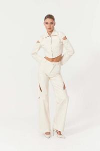 A model wearing the Jendue Chaby denim co-ord set in cream white, styled against a white background. The look consists of a cropped zip-up denim jacket with a pointed collar and cut-out openings at the shoulders, paired with high-waisted wide-leg denim tr