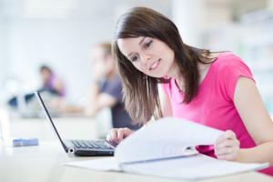 photo of a woman at a lap top computer take a course online