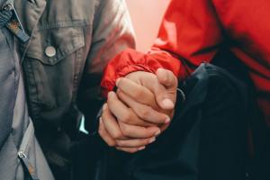 Asana Recovery Launches LGBTQ+ Addiction Treatment Program for Fountain Valley 23 Close-up of two hands clasped in mutual support, representing the family, partner, and chosen-family work integrated into Asana Recovery's LGBTQ+ specialty program in Orange County.
