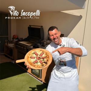 Pizza Master Vito Iacopelli with a steak pizza prepared on the collaboration grill.