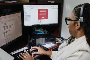 Natasha Broxton working at a computer workstation reviewing business systems and operational workflows.