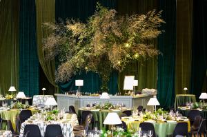 Rose of Sharon Floral Design Studio's 20-foot statement tree installation anchors the bar area at the Thaden School gala, featuring locally-foraged bamboo and smilax supported by metal framework. Photo by Kaity Whitman, Rose of Sharon Floral Design Studio
