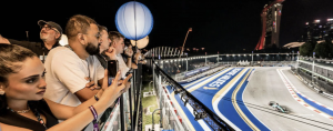 With 3-day general admission tickets to the 2026 Formula 1 Singapore Airlines Singapore Grand Prix already sold out on the official channel and Marina Bay hotel rates climbing sharply for race week, KKday, as an authorised ticketing partner of the Singapore Grand Prix, today opened its allocation of grandstand-and-hotel bundle packages to international travellers, with a sharpened focus on fans booking from the United States and Australia Spectators overlook the brightly lit Marina Bay Street Circuit from a luxury hospitality suite as a racing car speeds by during the night-time f1 singapore Grand Prix.